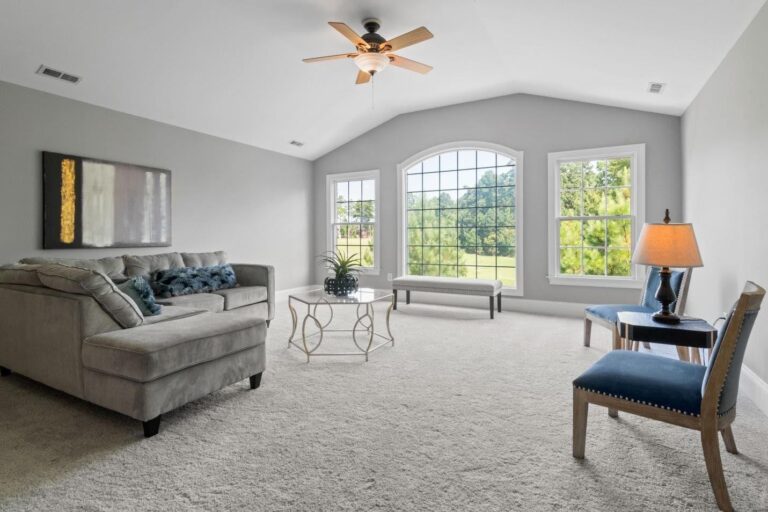 large open space living room, grey carpet, white walls